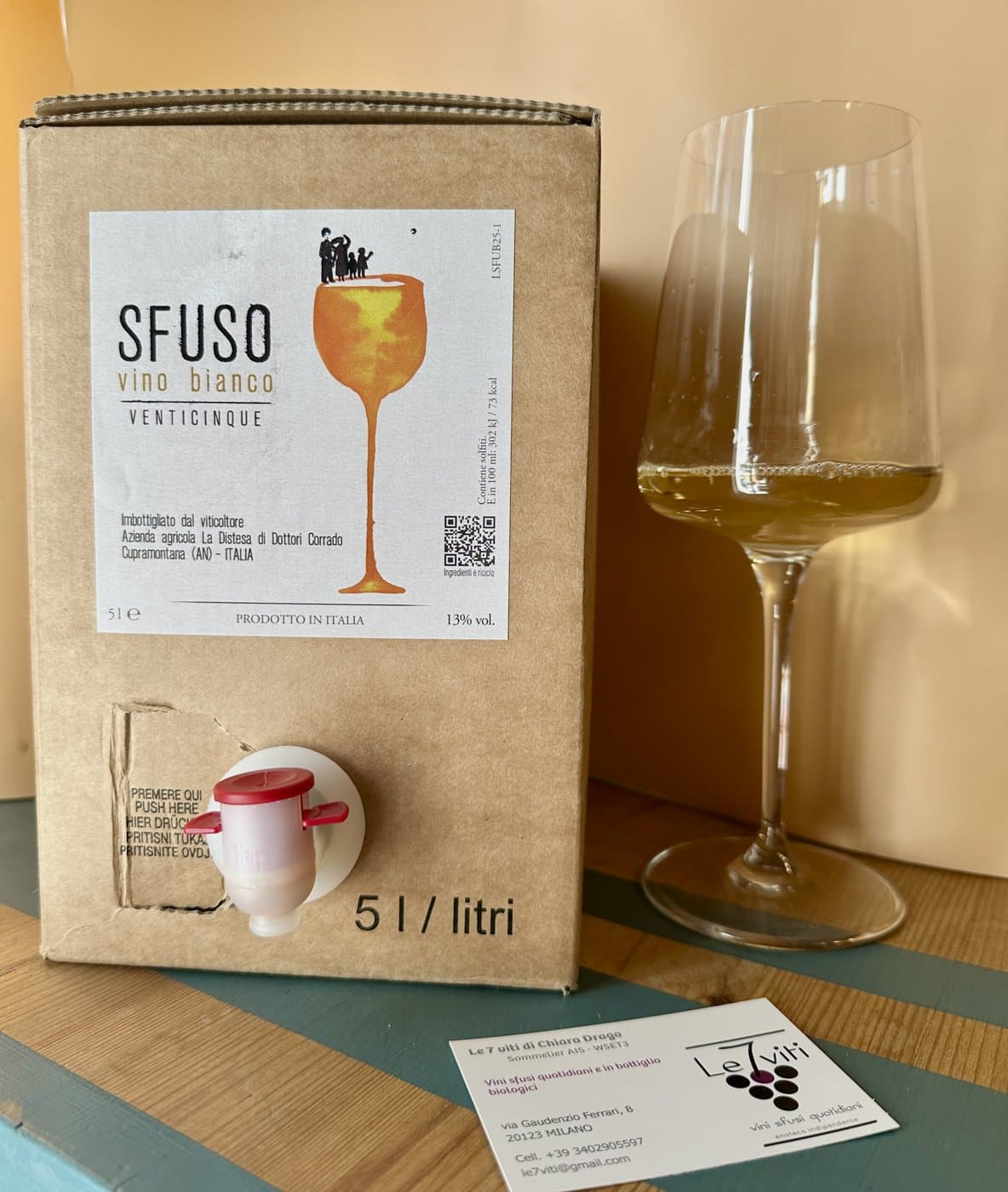 Bag-in-box da 5 litri di vino bianco sfuso accanto a un calice